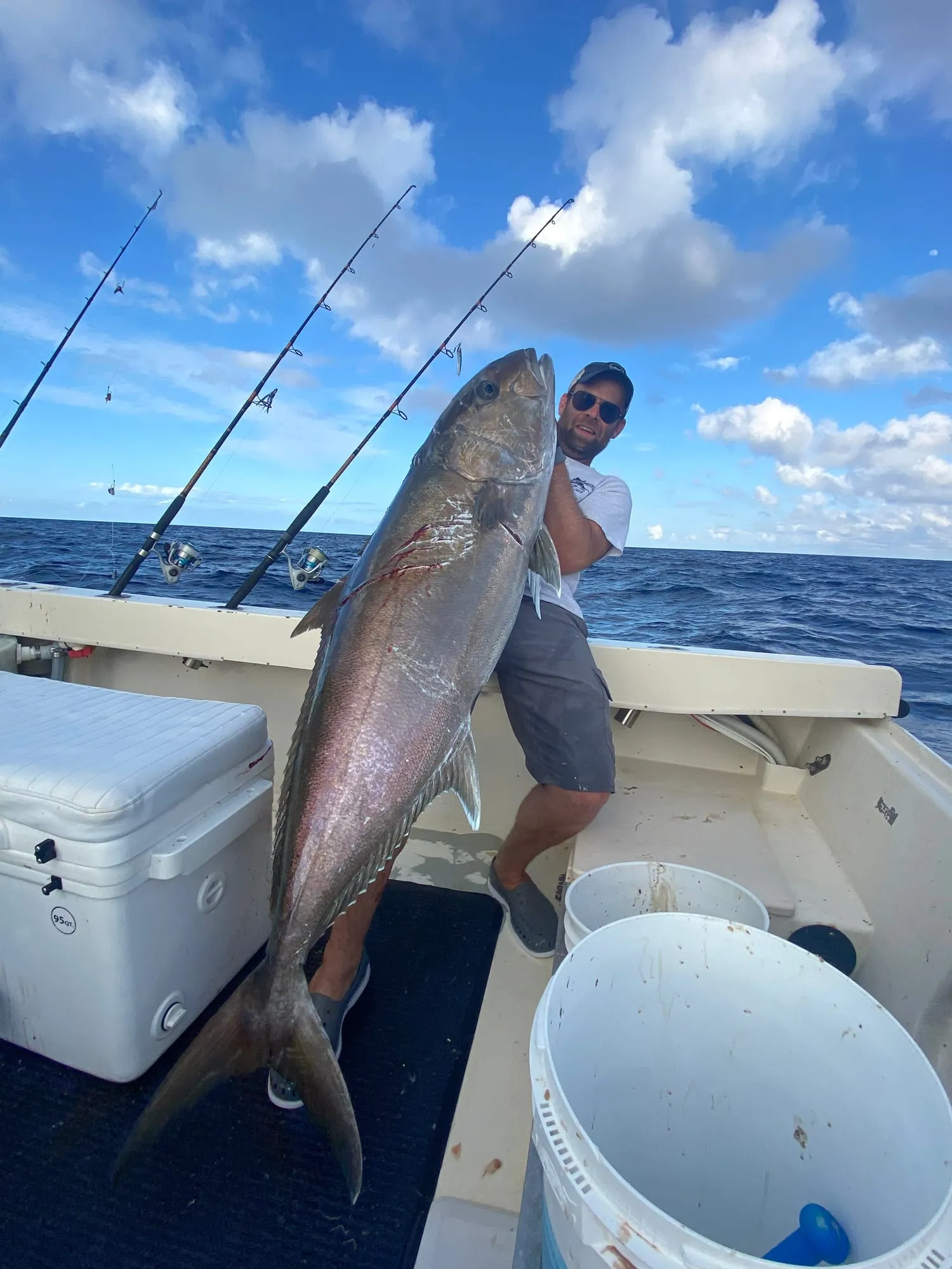 Angler holding a big amberjack on deck