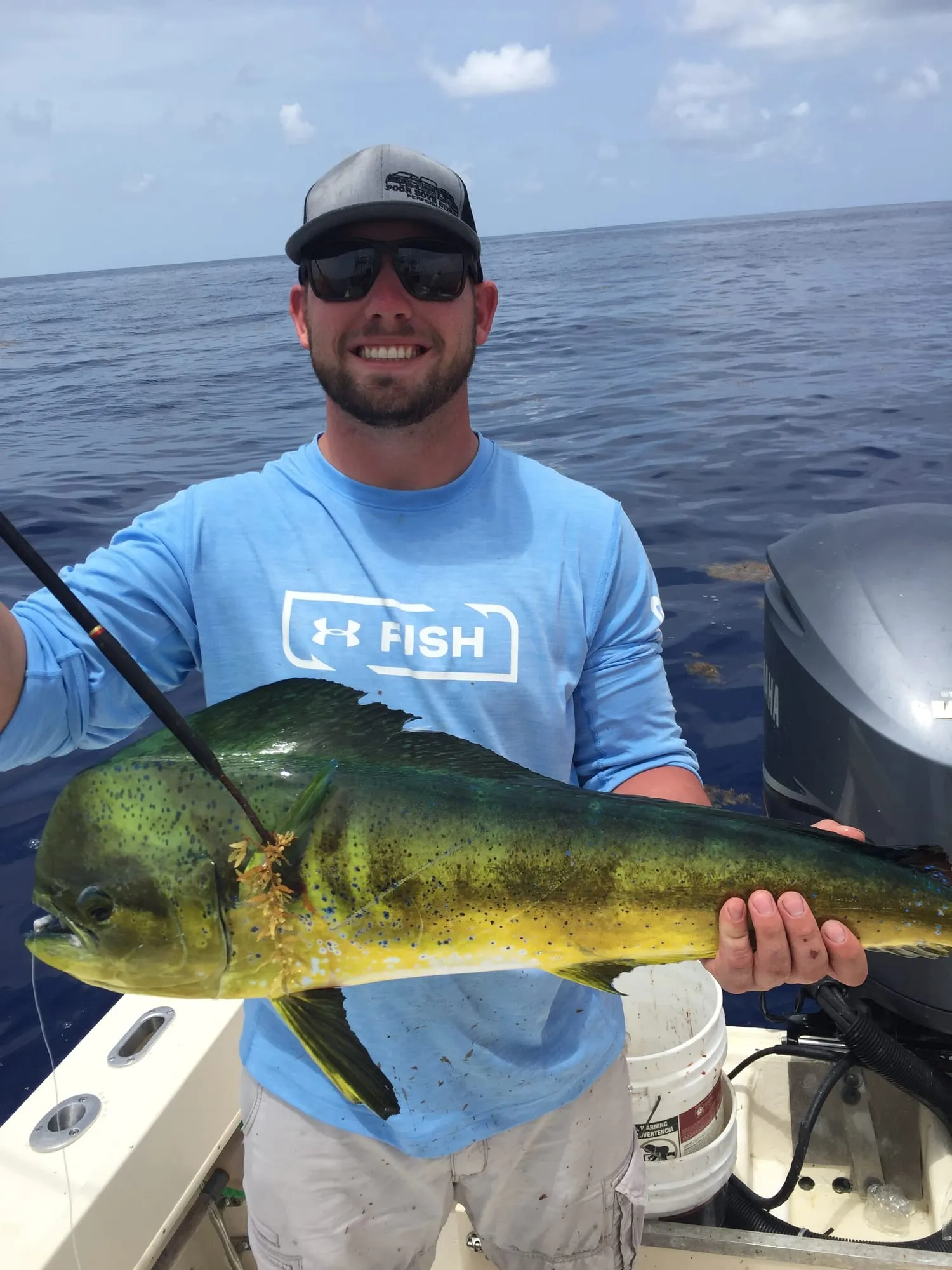 Angler holding a mahi-mahi aboard Satisfaction
