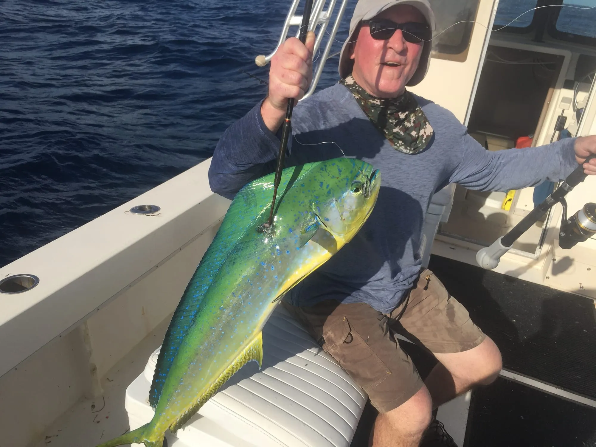 Young angler in the cockpit holding a mahi-mahi