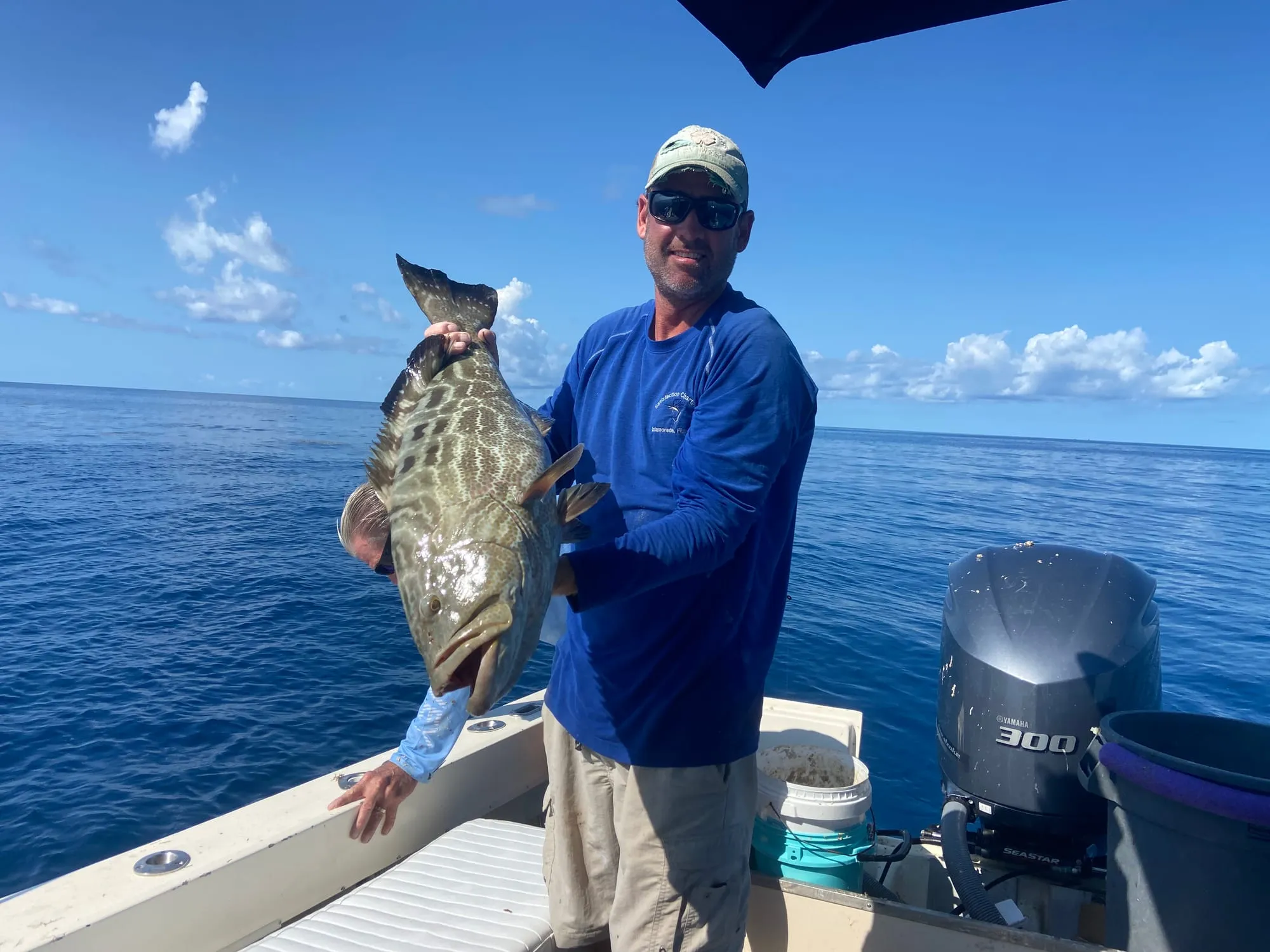 Angler grinning with a grouper offshore