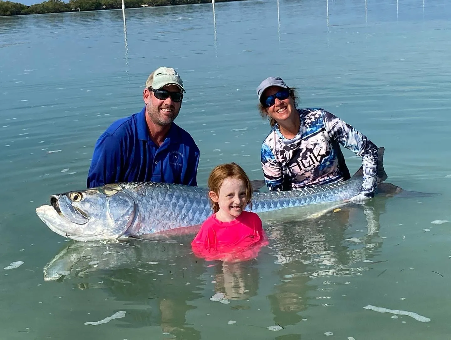 Family in the shallows releasing a big tarpon